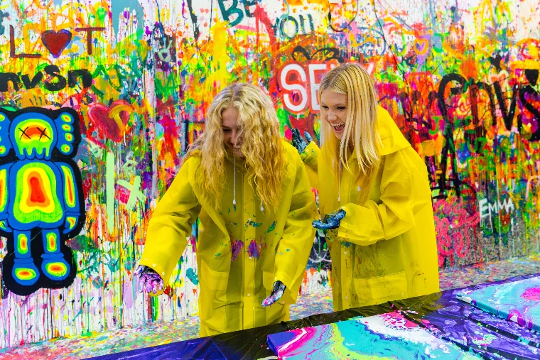 Friends covered in paint in the splatter room